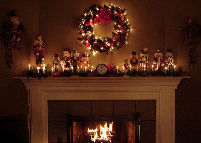 Christmas wreath and fairy lights above a log burning fireplace